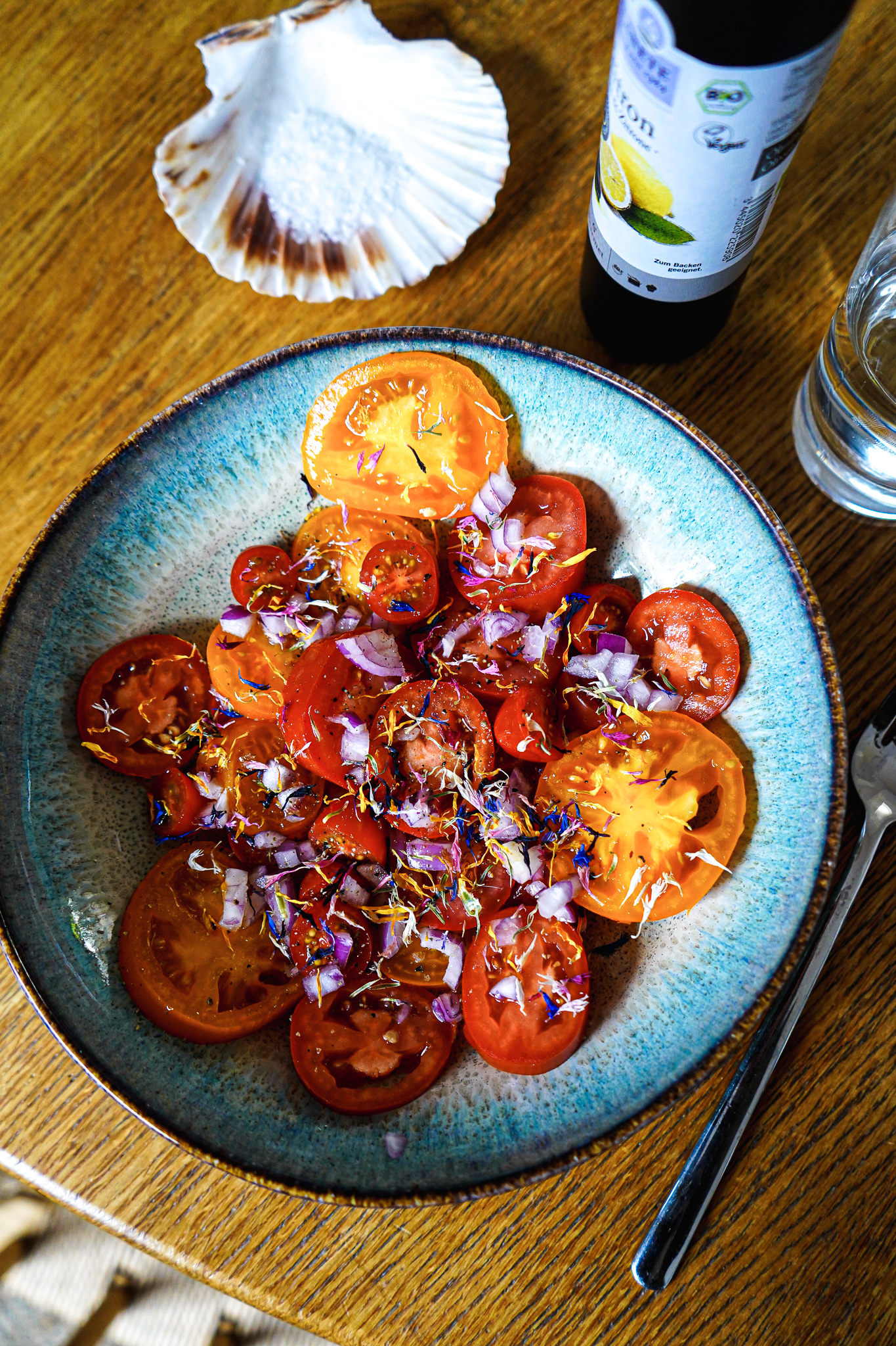 Schöner Salat mit Heirloom Tomaten, roten Zwiebeln und Kornblumen